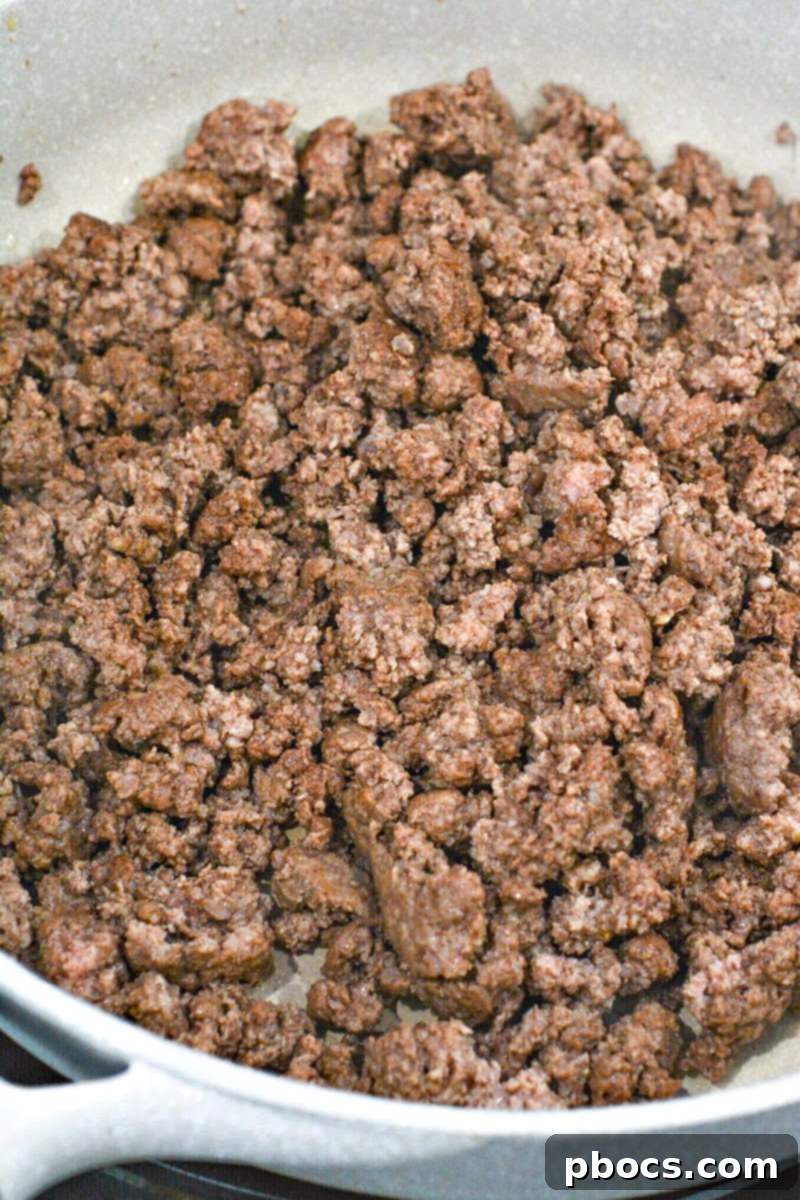 Browning ground beef in a skillet, draining excess grease