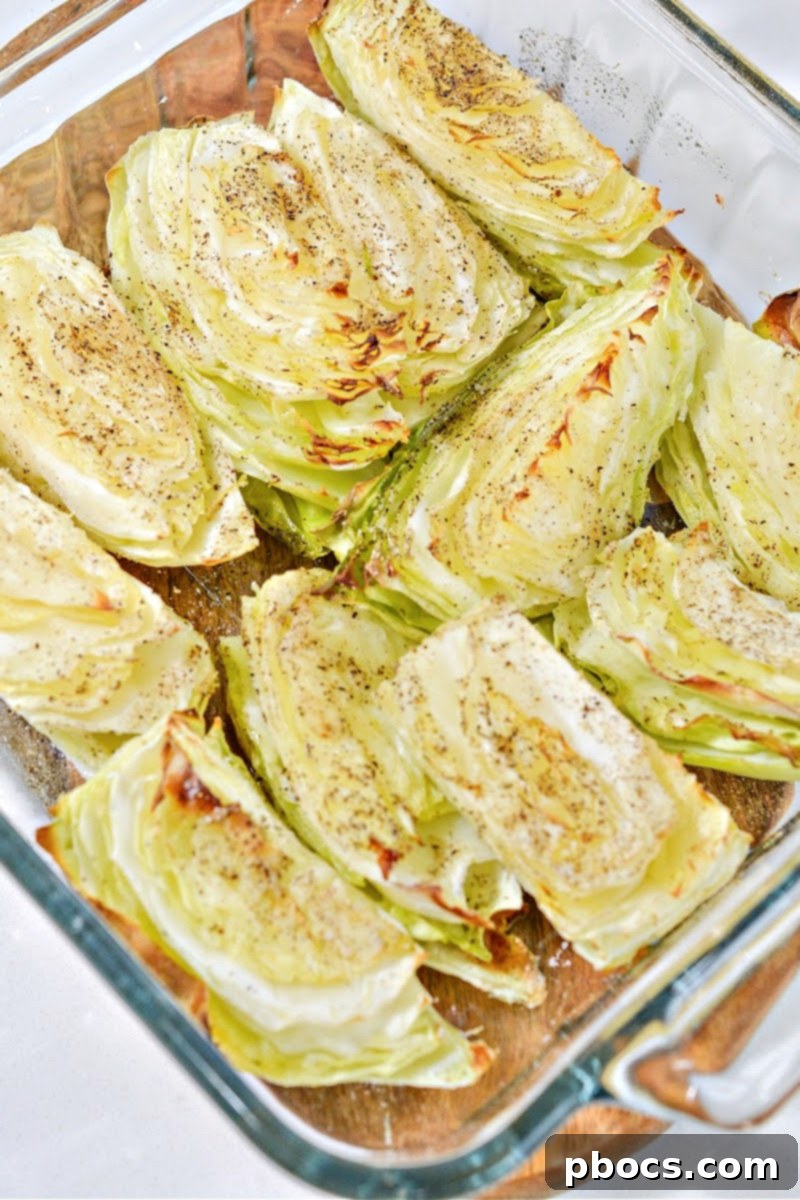 Cabbage wedges seasoned with olive oil, salt, and pepper in a baking dish