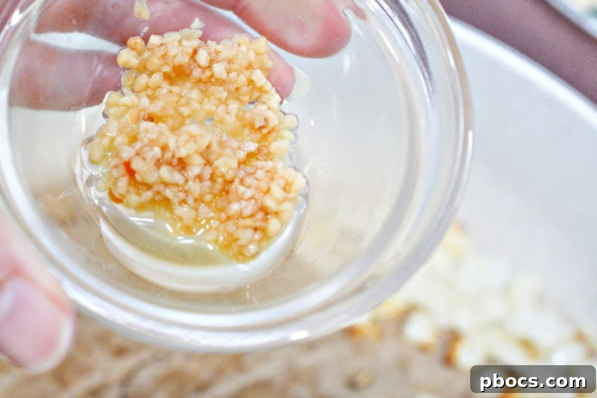 Minced garlic added to sauteed onions in a skillet
