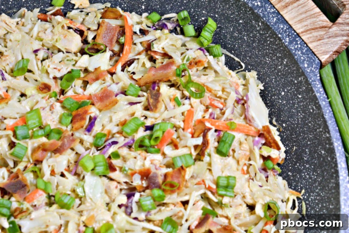 Closeup of Keto Crack Slaw in a skillet, showing the blending of ingredients before serving.