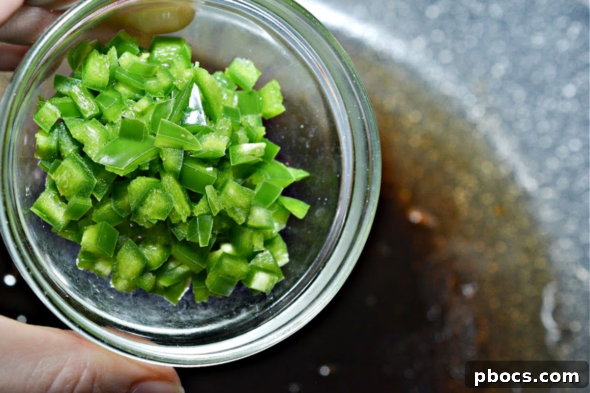 Bacon cooking in a skillet, ready to be crumbled for Keto Crack Slaw.