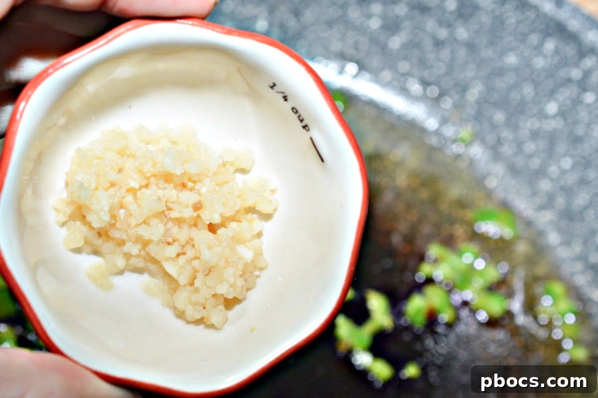 Jalapenos sautéing in a skillet with olive oil for Keto Crack Slaw.