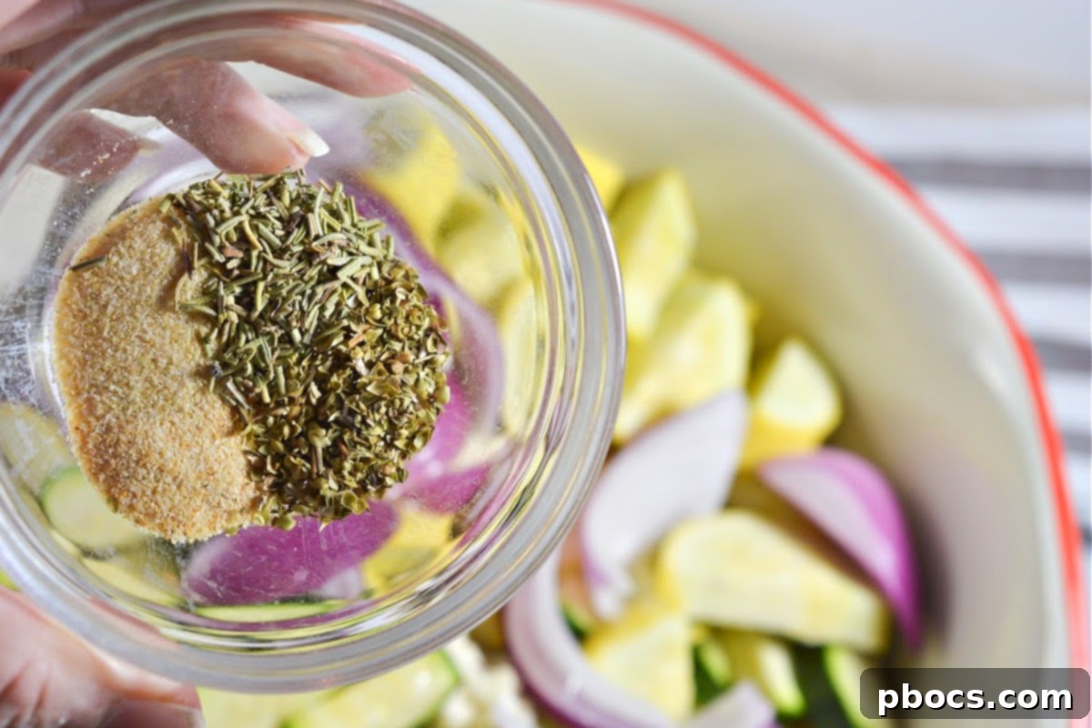 Low-Carb Sheet Pan Sausage and Veggies - Seasoned vegetables being tossed in a bowl