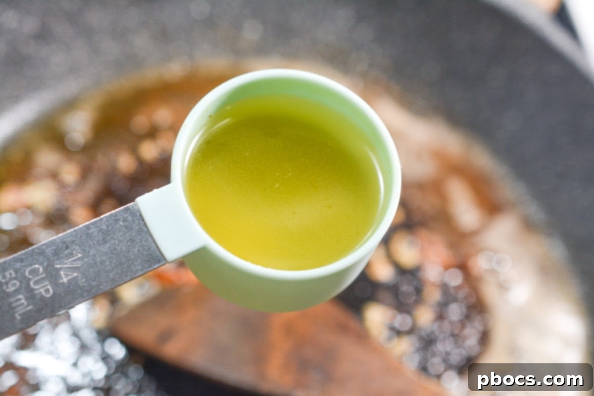 Creamy Tomato Basil Keto Chicken Skillet 12 Minced garlic being stirred into melted butter in a skillet