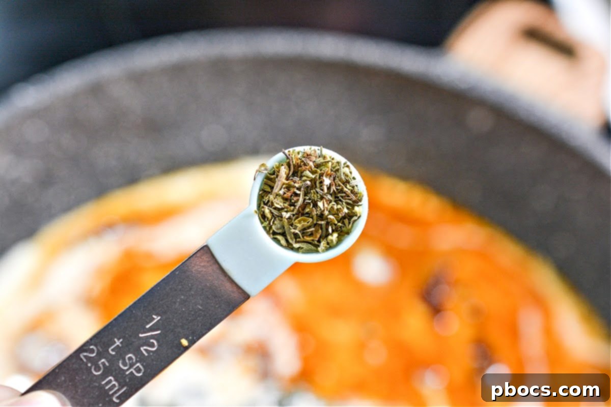 Creamy Tomato Basil Keto Chicken Skillet 14 Ingredients for the cream sauce being stirred into the skillet