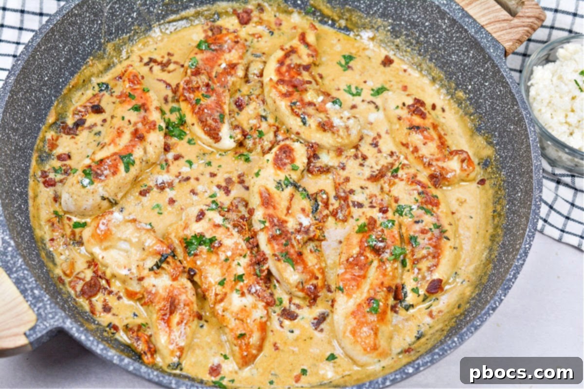 Creamy Tomato Basil Keto Chicken Skillet 16 Parmesan cheese being stirred into the thickened cream sauce