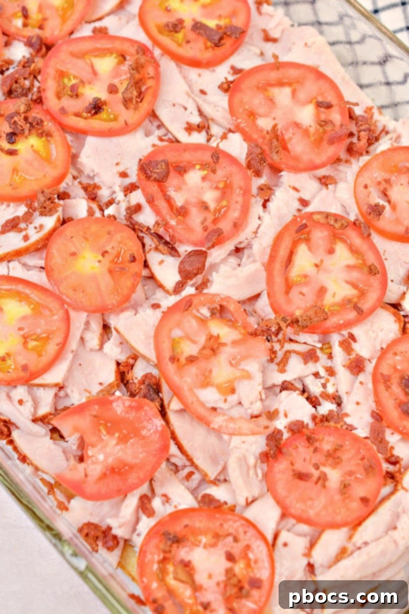 Kentucky Hot Brown Keto Bake 15 Layering Turkey, Bacon, and Tomatoes on the Baked Bread Base