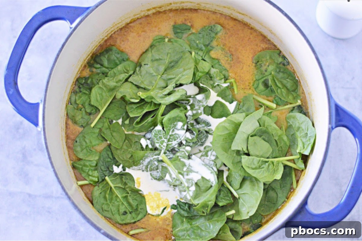 Creamy keto pumpkin curry soup simmering on the stove