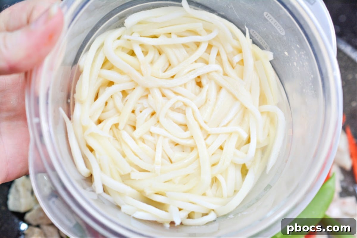 Sautéing chicken pieces in a skillet for the chow mein.
