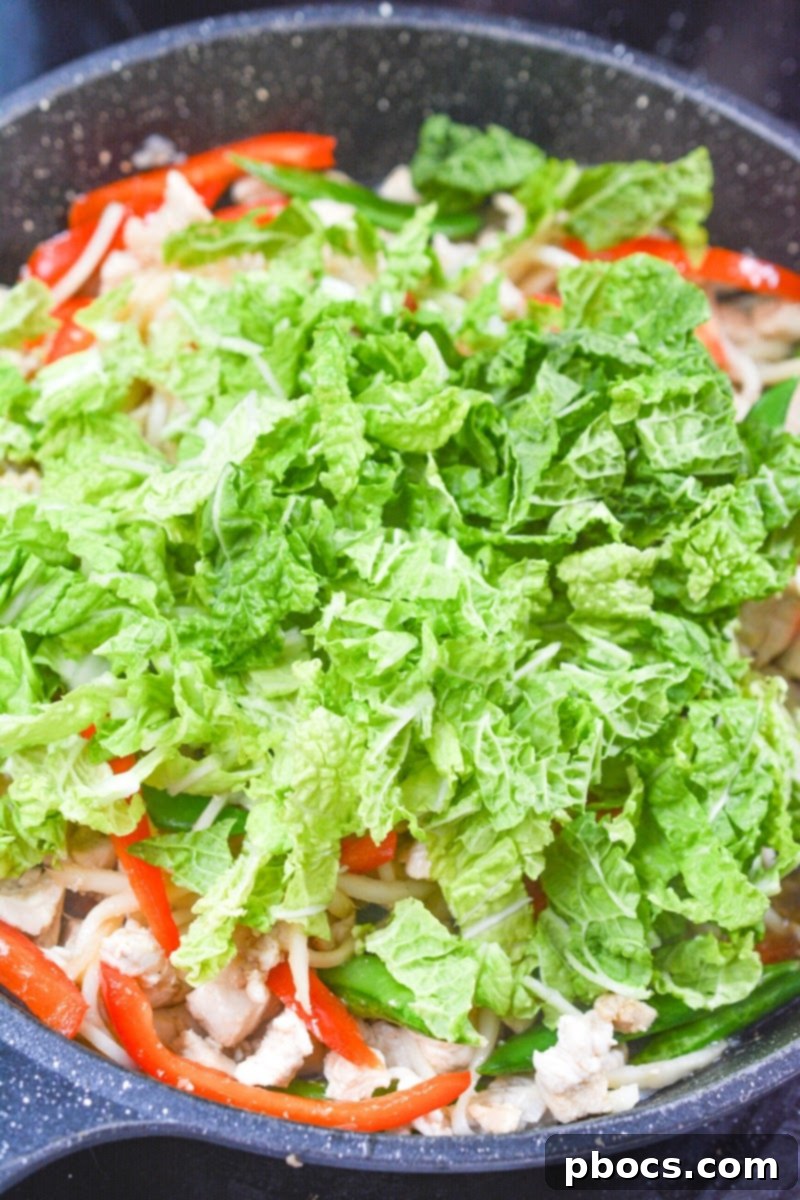 Adding snow peas, Palmini noodles, and bell pepper to the skillet.