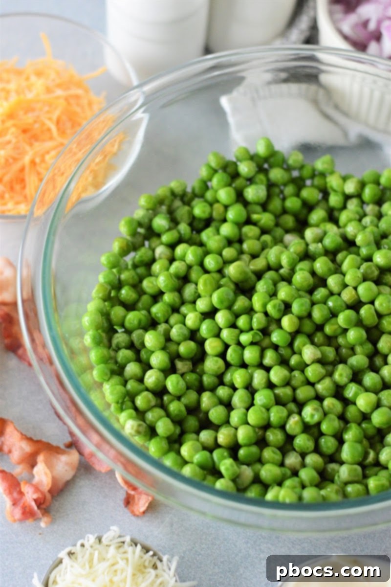 Keto-Friendly Pea Salad Delight 8 Combining thawed peas and mayo in a bowl.