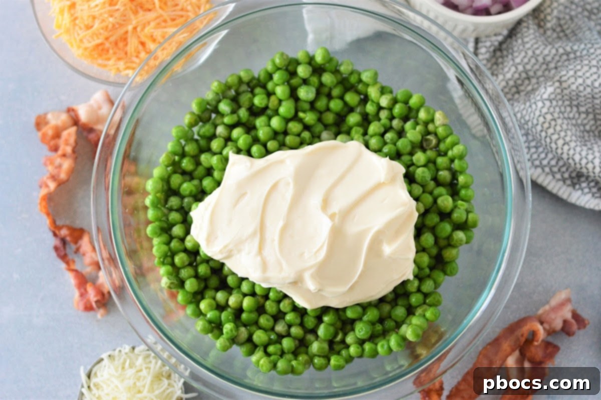 Keto-Friendly Pea Salad Delight 9 Mixing onion, bacon, and cheese into the pea salad base.