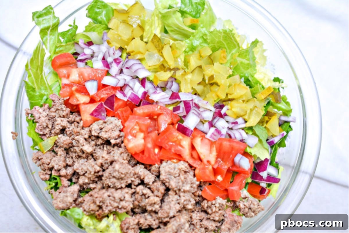 Layering toppings on Keto Big Mac Salad