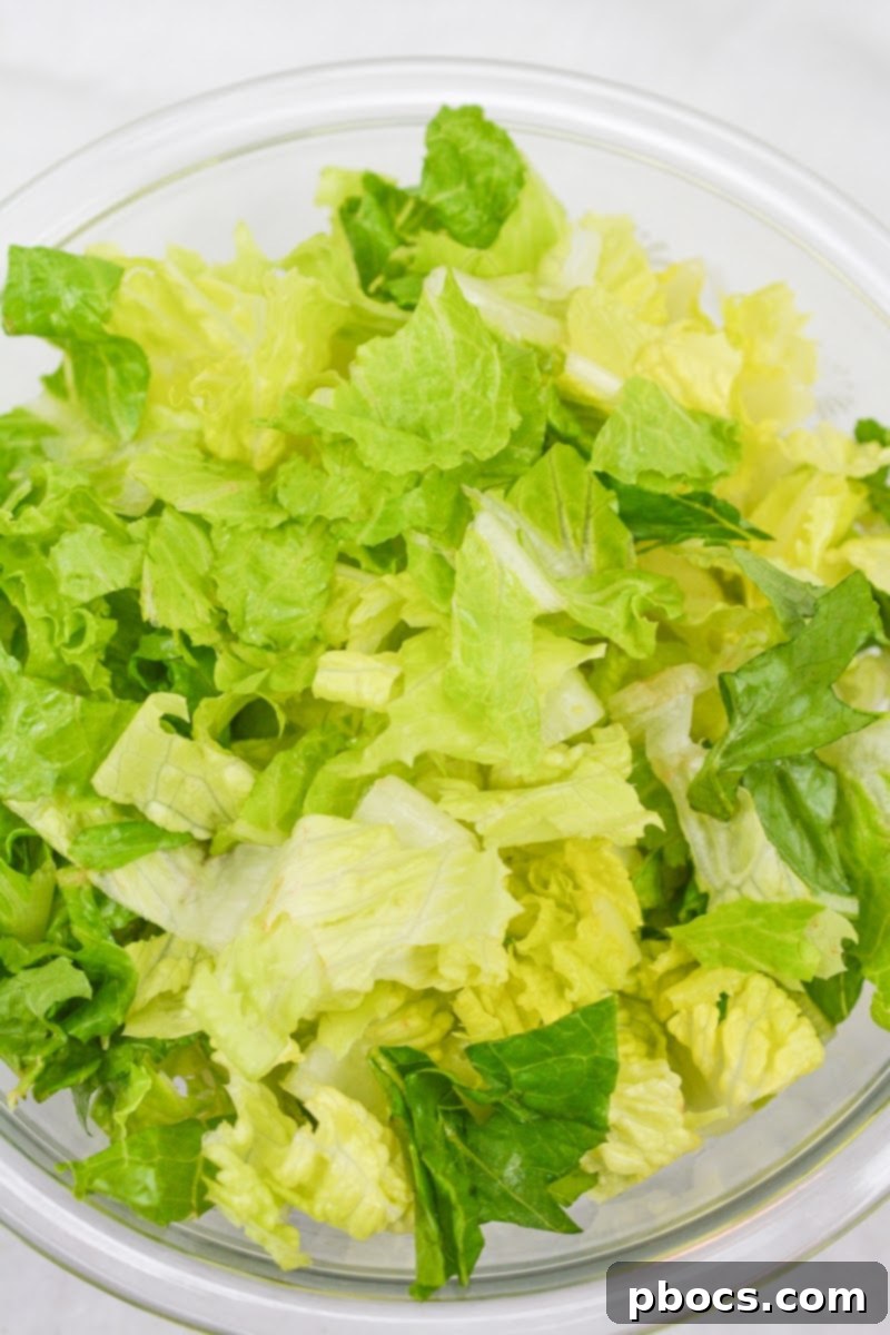 Adding lettuce to a serving bowl