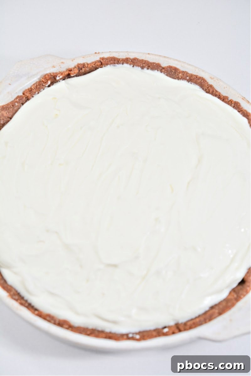 Spreading cheesecake mixture over the crust