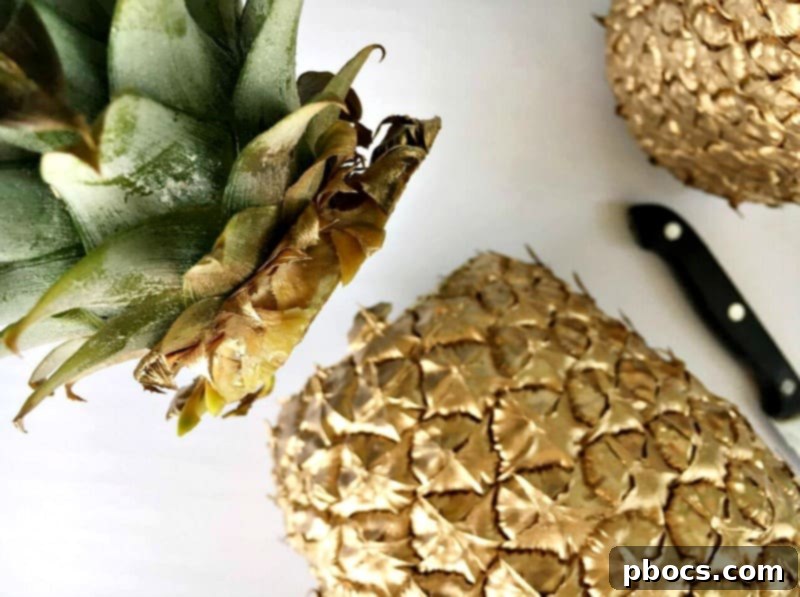 Cutting off the crown of a pineapple for the DIY vase project.