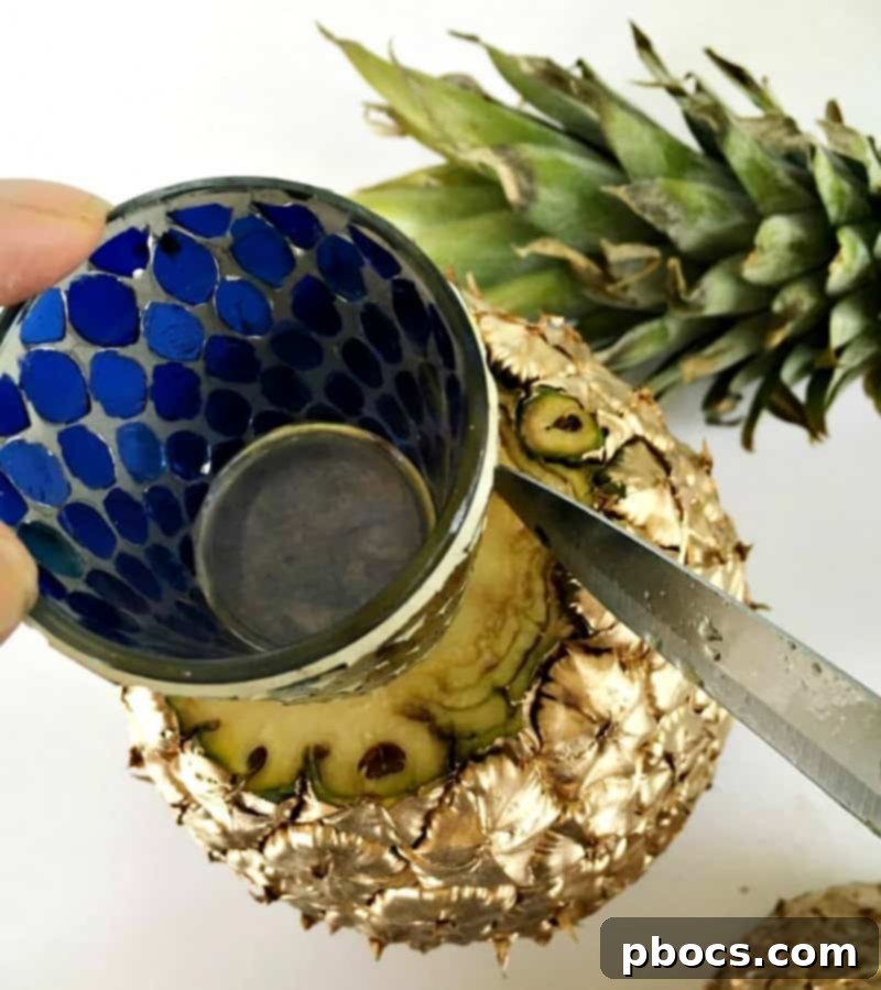 Tracing the votive opening on a pineapple before hollowing it out.