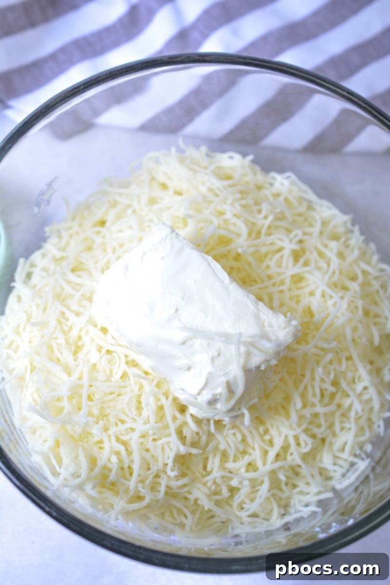 Keto Crave Biscuits 8 Keto Crack Biscuits - Step 1: Melting the cheeses in a microwave-safe bowl.