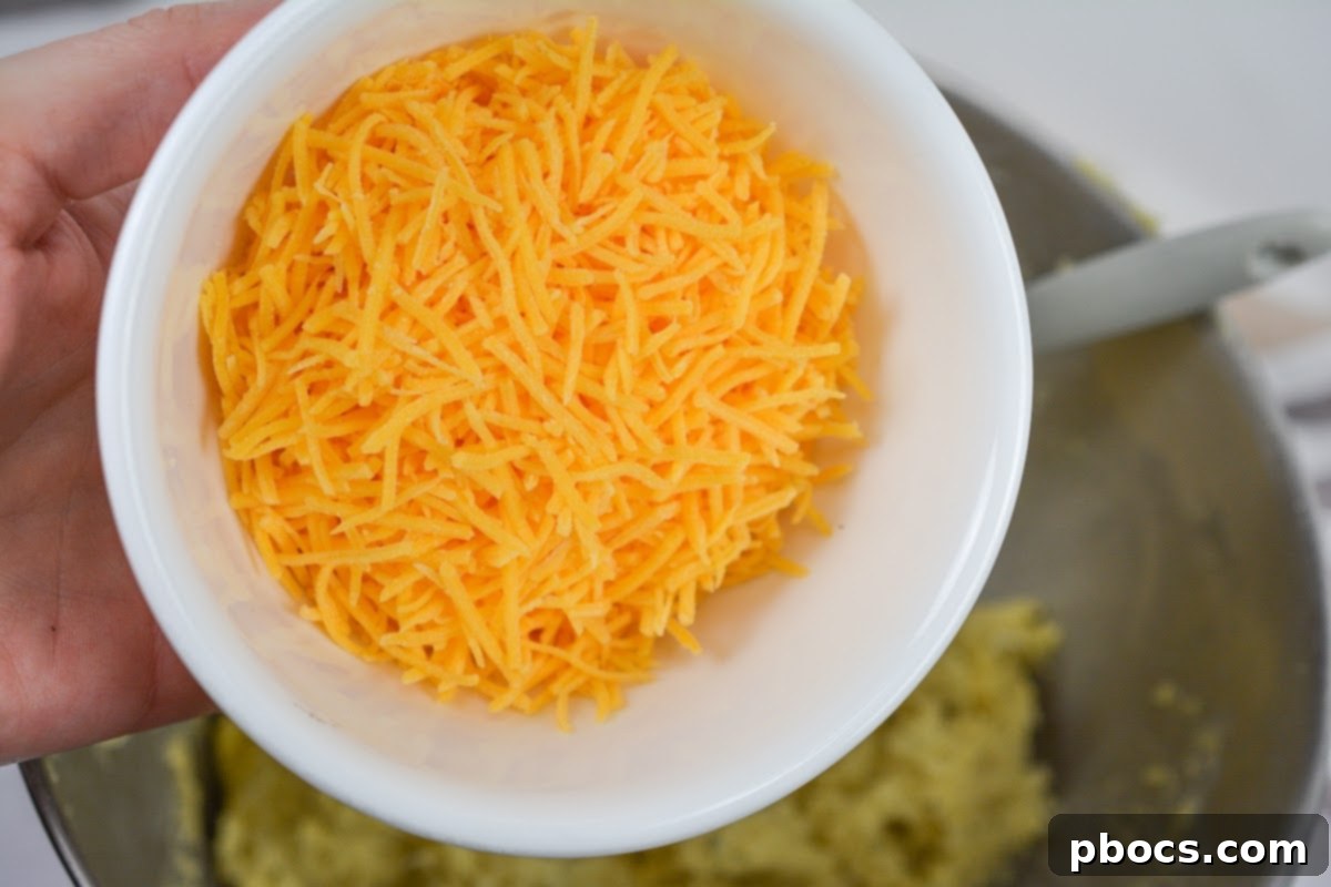 Keto Crave Biscuits 10 Keto Crack Biscuits - Step 3: Folding in cheddar cheese and bacon pieces into the dough.