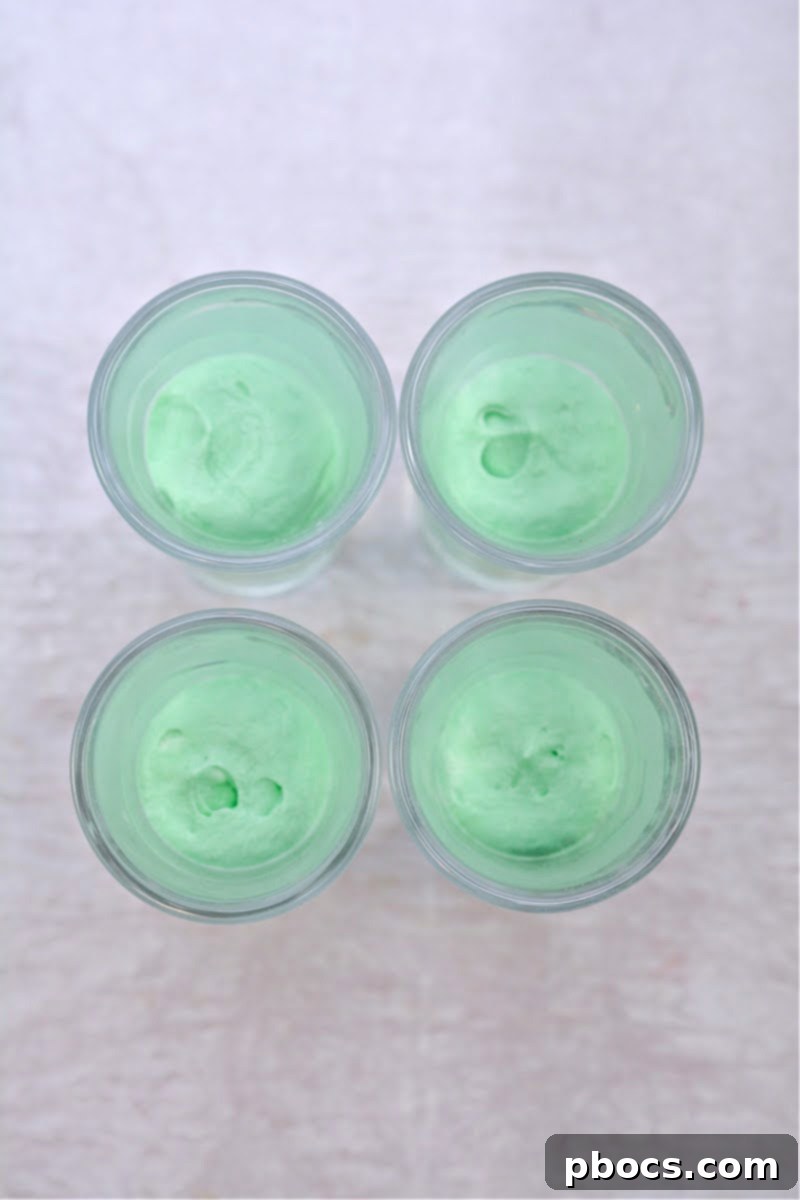 Decadent Keto White Chocolate Christmas Shooters 13 Two bowls of fluffy white chocolate cream, one colored red and one green.