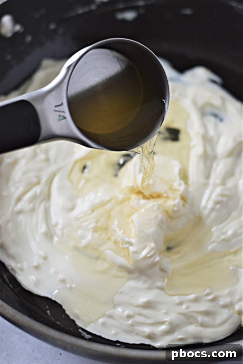 Creamy Keto Crab Rangoon Casserole 9 Garlic cooking in butter in a saucepan