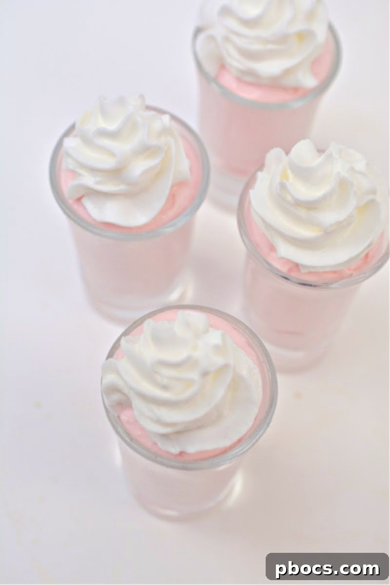 Piping strawberry cream into shot glasses