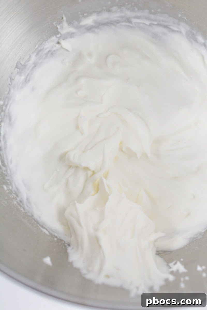 Beating heavy whipping cream and Swerve until stiff peaks form