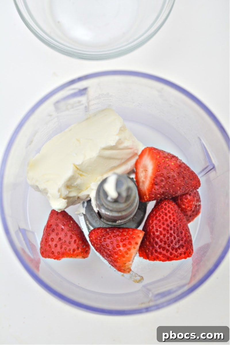 Blending strawberries, cream cheese, and vanilla until smooth