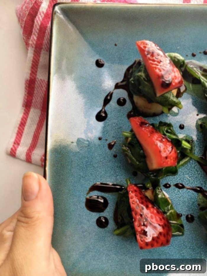 Close-up of the elegant Scallops, Spinach & Strawberries With Balsamic Syrup appetizer, highlighting the textures and vibrant colors.