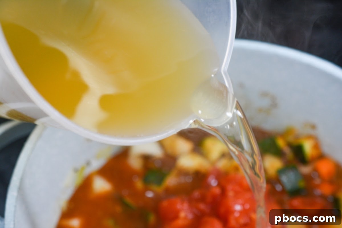 Pouring chicken broth and diced tomatoes into the pot