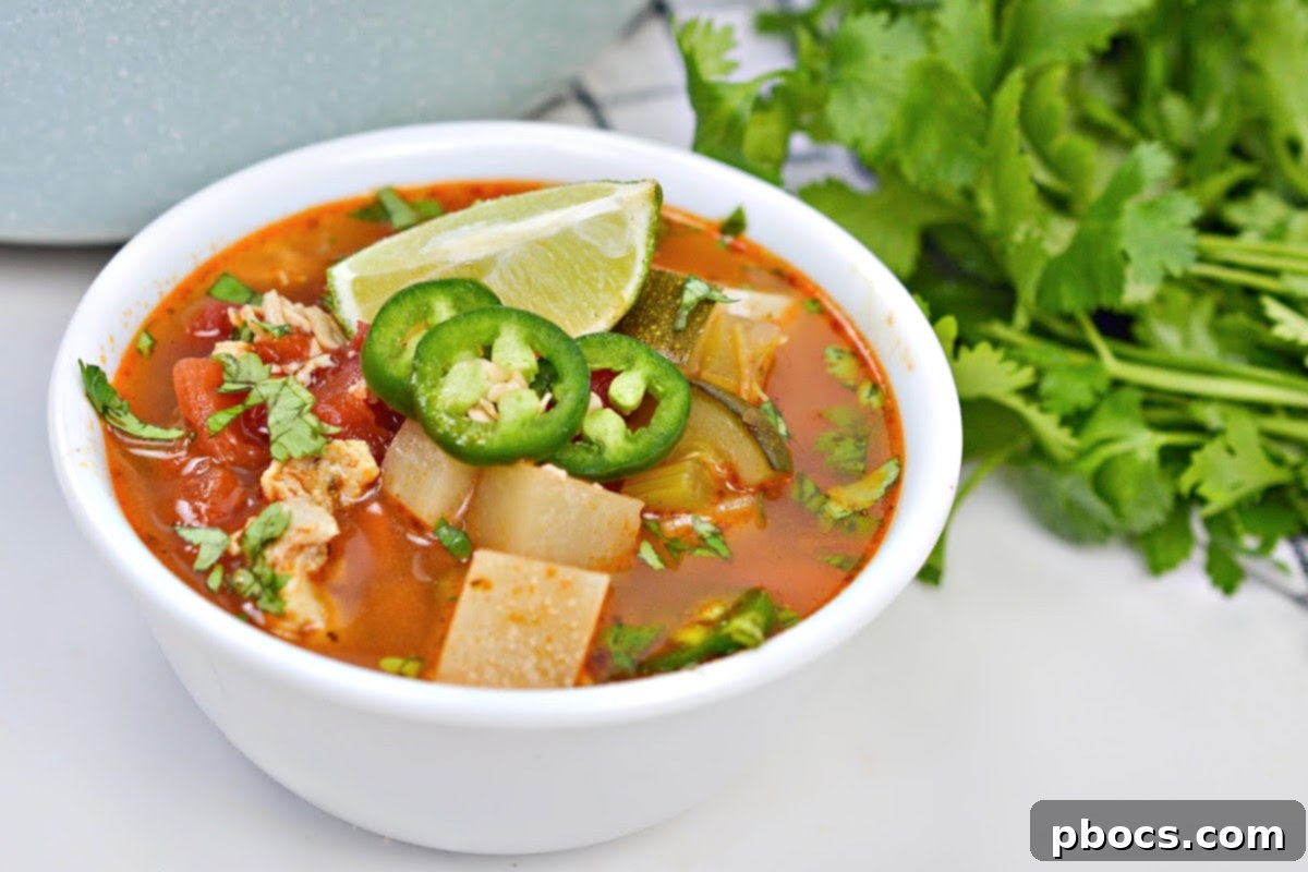 Low-Carb Chicken Caldo De Pollo garnished with cilantro and lime
