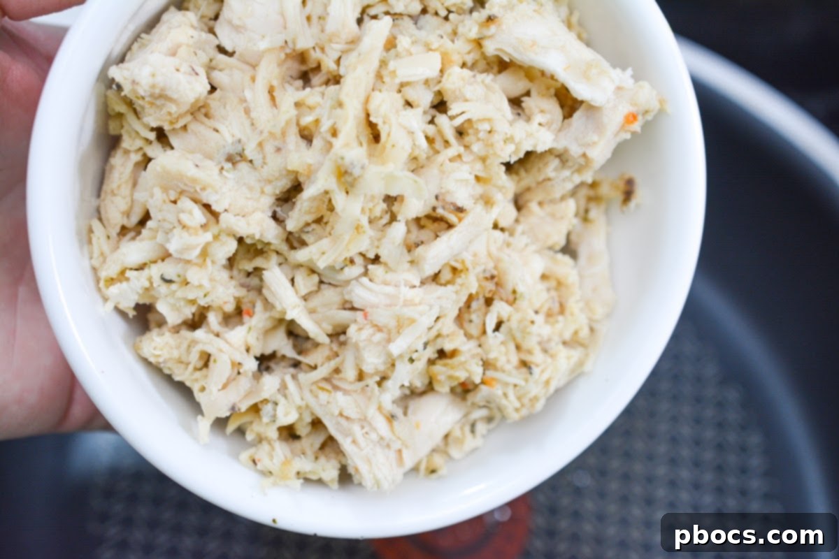 Sautéing shredded chicken with taco seasoning and garlic