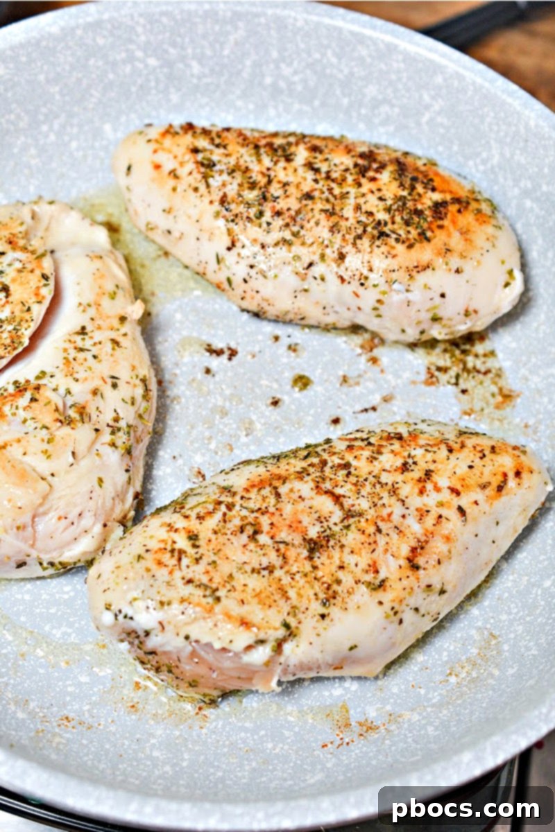 Antipasto-Loaded Keto Hasselback Chicken 10 Searing chicken breasts in a hot skillet