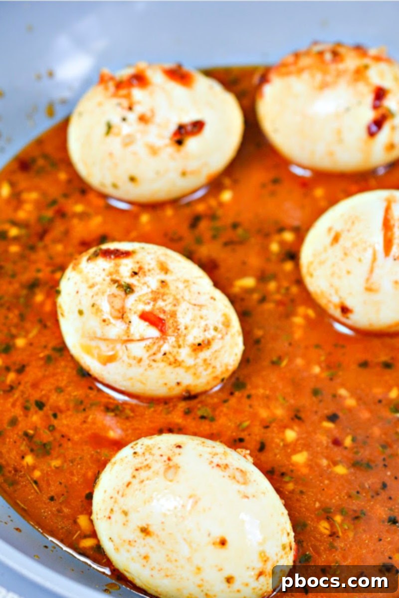 Close-up of seasoned hard-boiled eggs in a spicy sauce