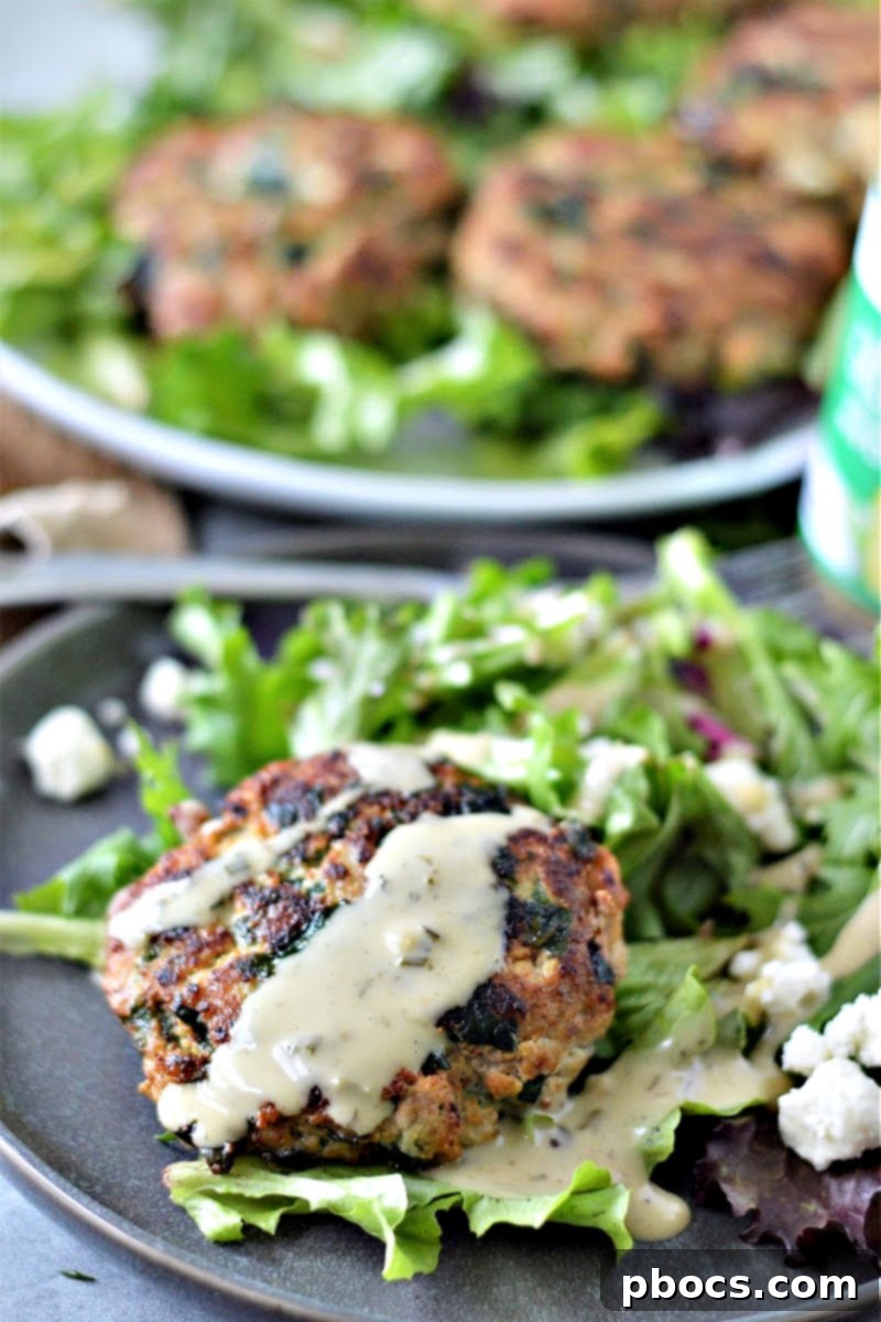 Juicy Keto Spinach Feta Turkey Burger served on a bed of greens