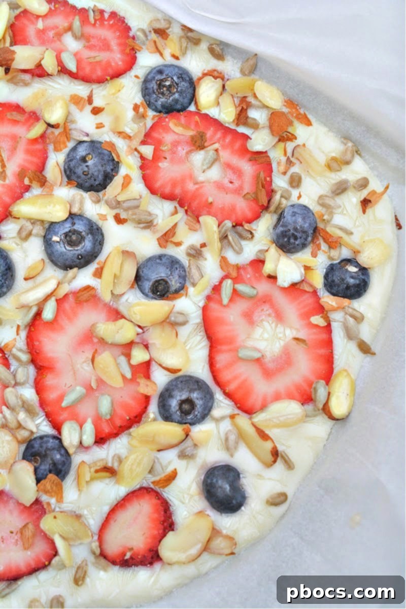 Ingredients for keto frozen yogurt bark, including yogurt, berries, and nuts