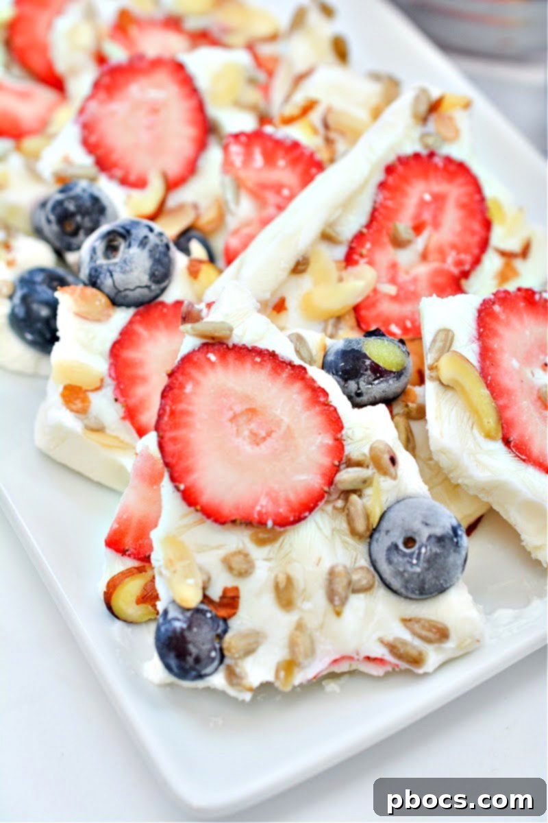 Keto frozen yogurt bark with red strawberries and blueberries for patriotic holidays