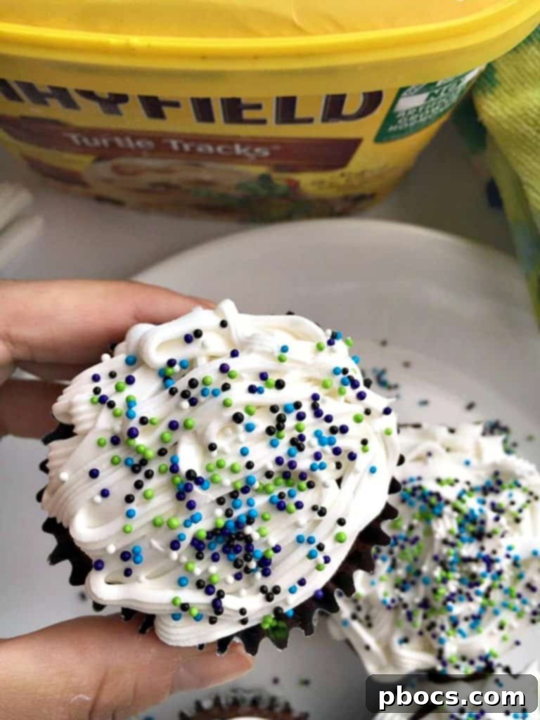Close-up of a decorated ice cream filled cupcake with colorful sprinkles