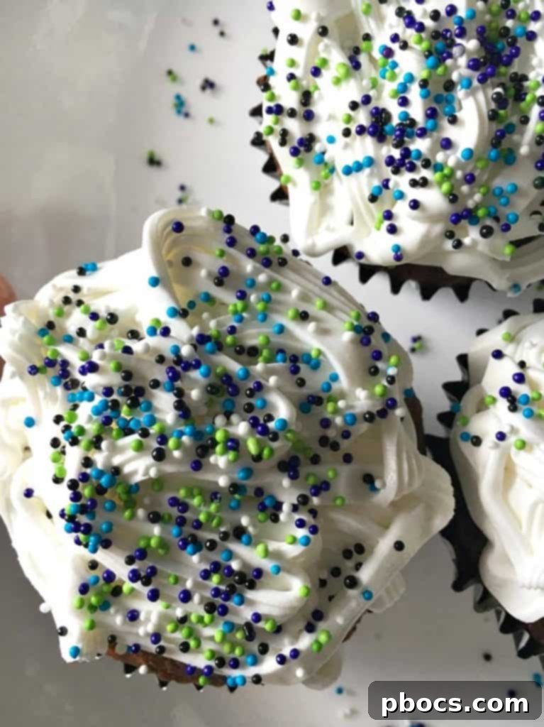 Applying a generous layer of white icing to a freshly filled and chilled cupcake