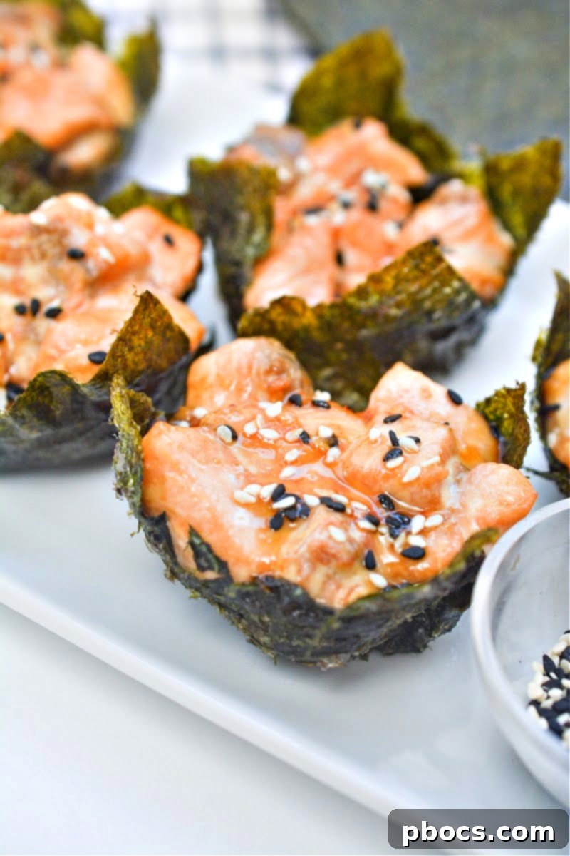 Salmon Sushi Nori Cups on a plate, garnished with sesame seeds