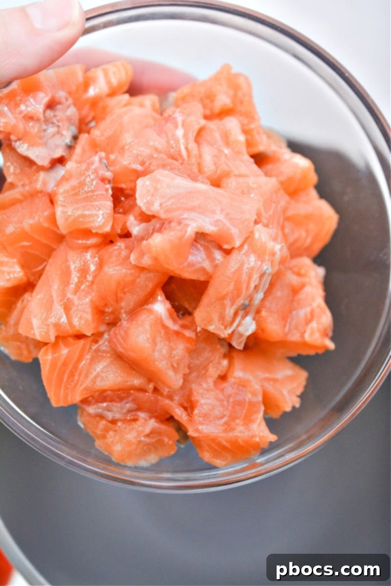 A bowl filled with raw, diced salmon, ready for seasoning