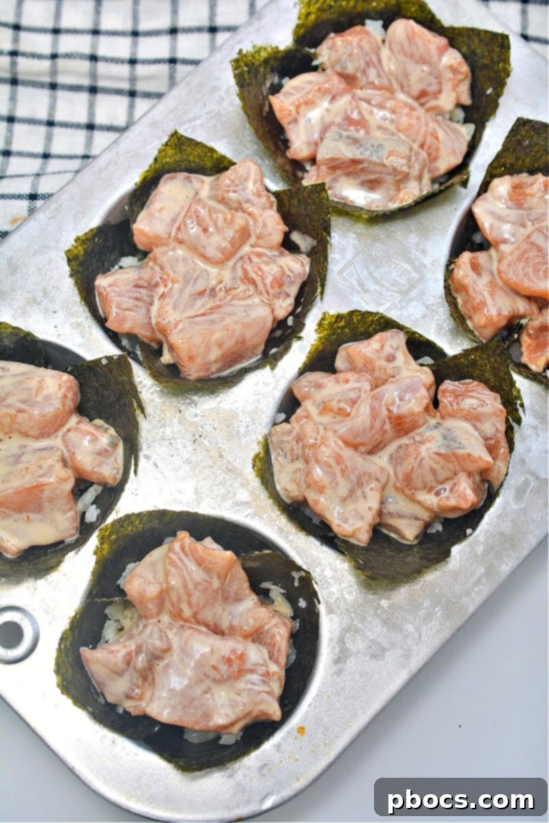 Raw salmon mixture spooned into the nori cups, nestled in a muffin tin