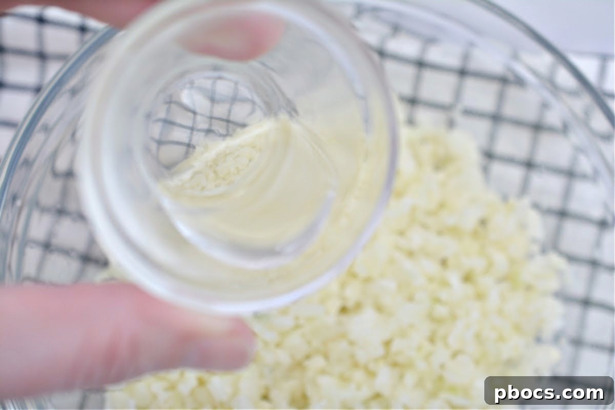 Adding rice vinegar to cooked cauliflower rice in a bowl