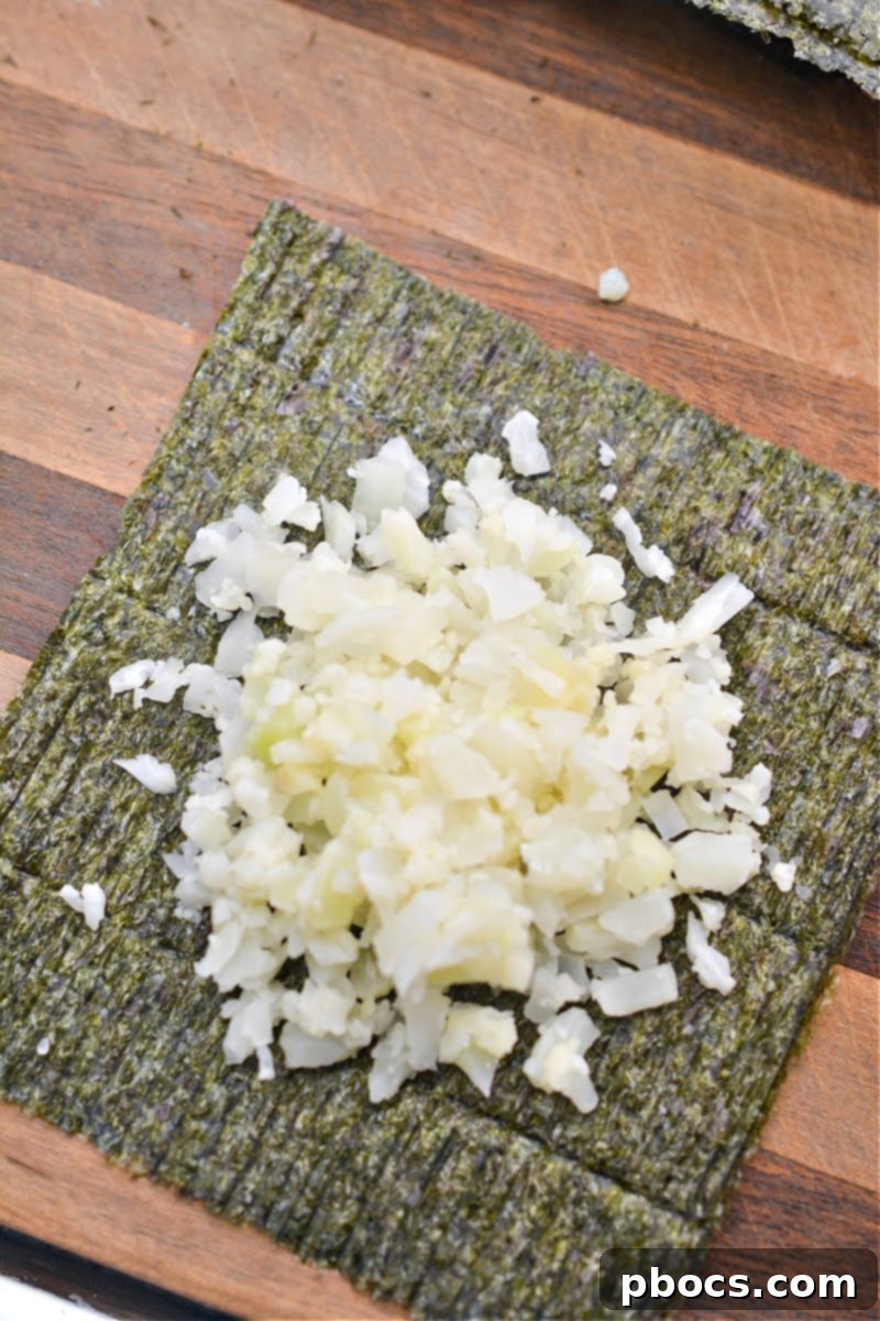 Cauliflower Rice placed in the middle of a Nori sheet, ready to be formed into a cup