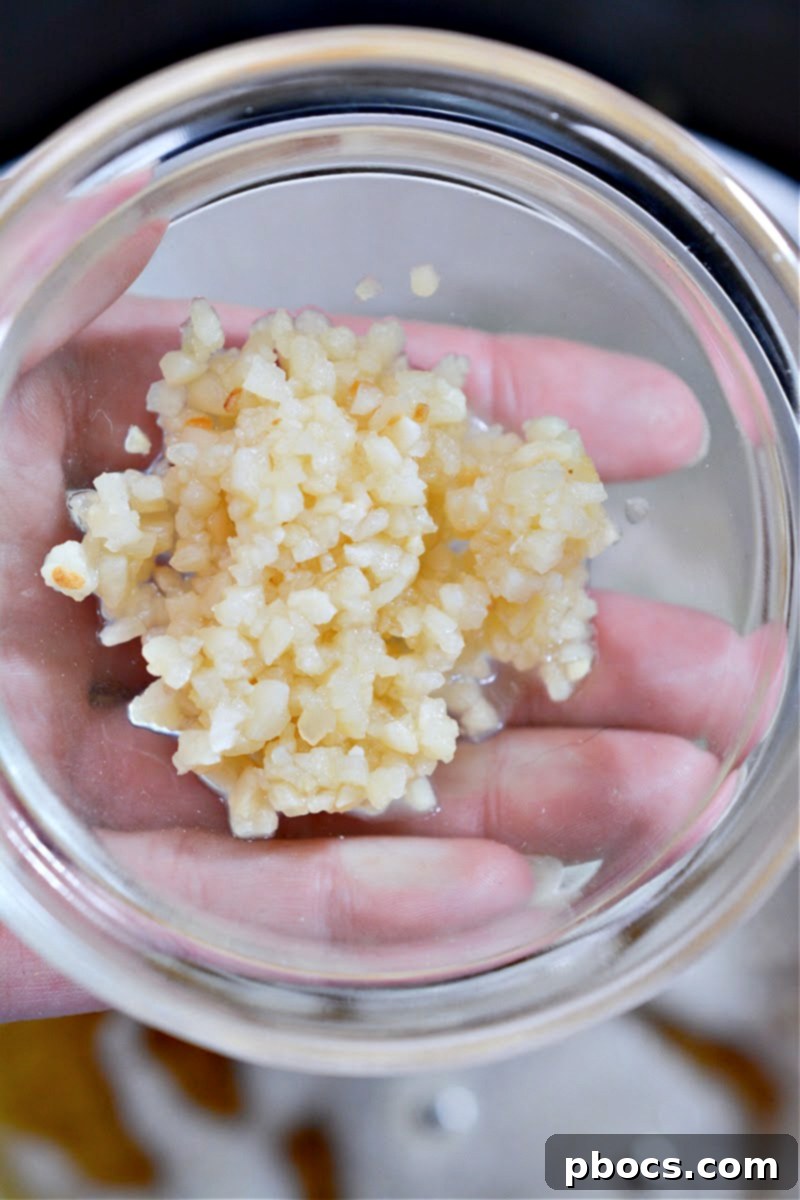 A close-up of beautifully roasted Brussels sprouts that have been smashed flat on a baking sheet, ready to absorb more flavor.
