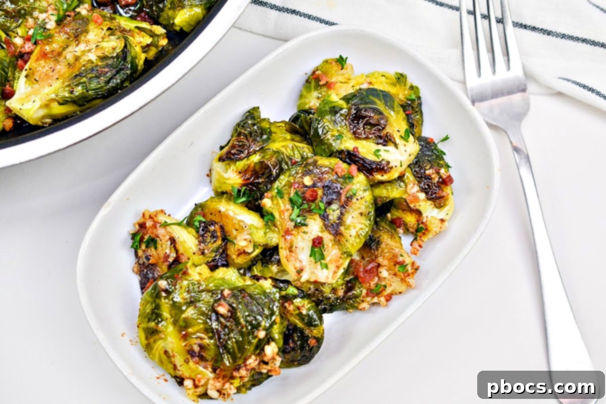 A close-up shot of cooked Brussels sprouts on a baking sheet, showing their readiness for the smashing step.