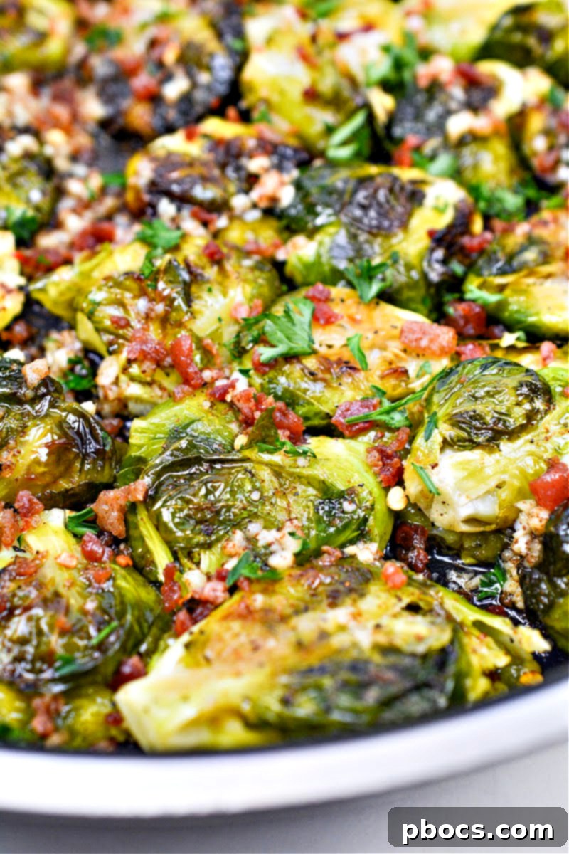 Keto Smashed Brown Butter Brussels Sprouts spread out on a baking sheet after being roasted and smashed, showcasing their crispy edges.