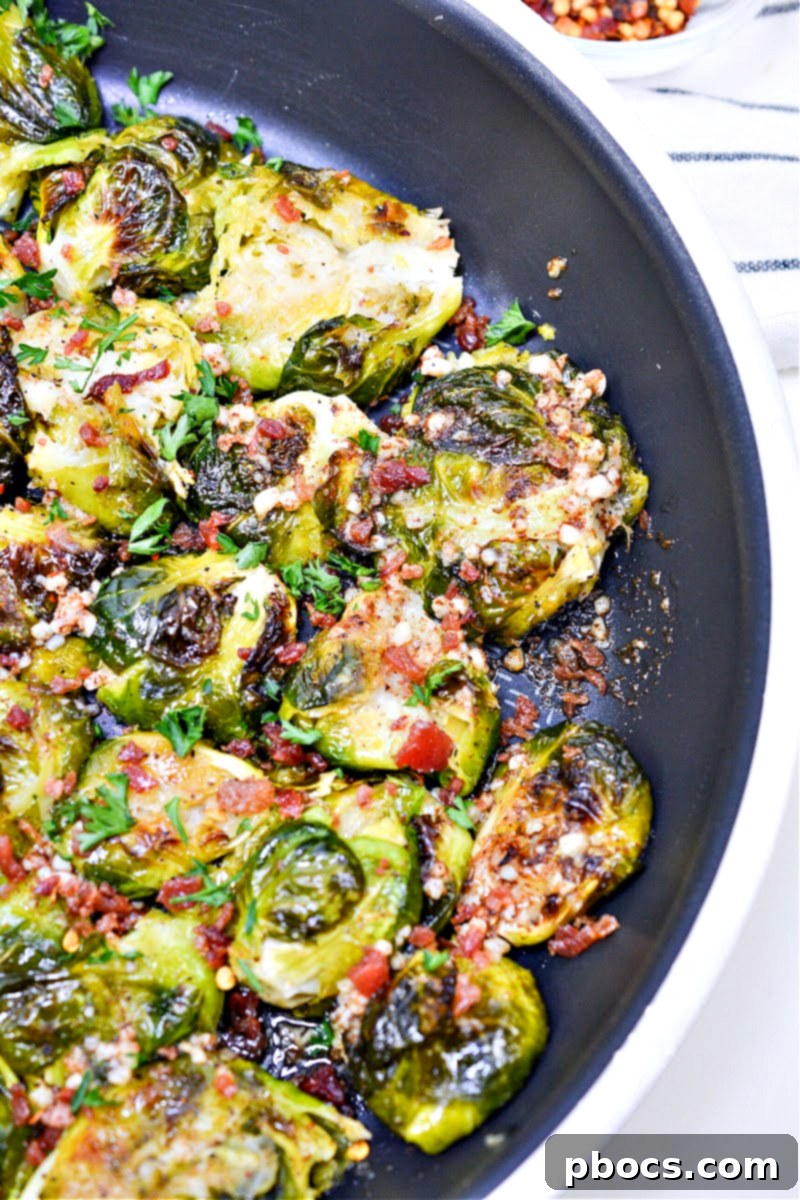 A plate of Keto Smashed Brown Butter Brussels Sprouts presented alongside a fork, inviting you to taste its perfection.
