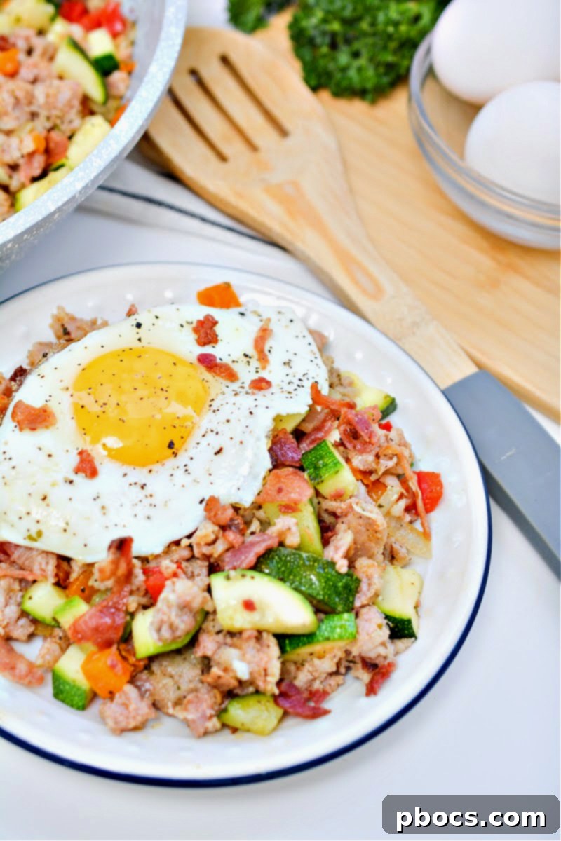 Keto Sausage Zucchini Breakfast Skillet 5 Serving suggestion for Keto Sausage and Zucchini Breakfast Hash on a plate, garnished with fresh herbs.