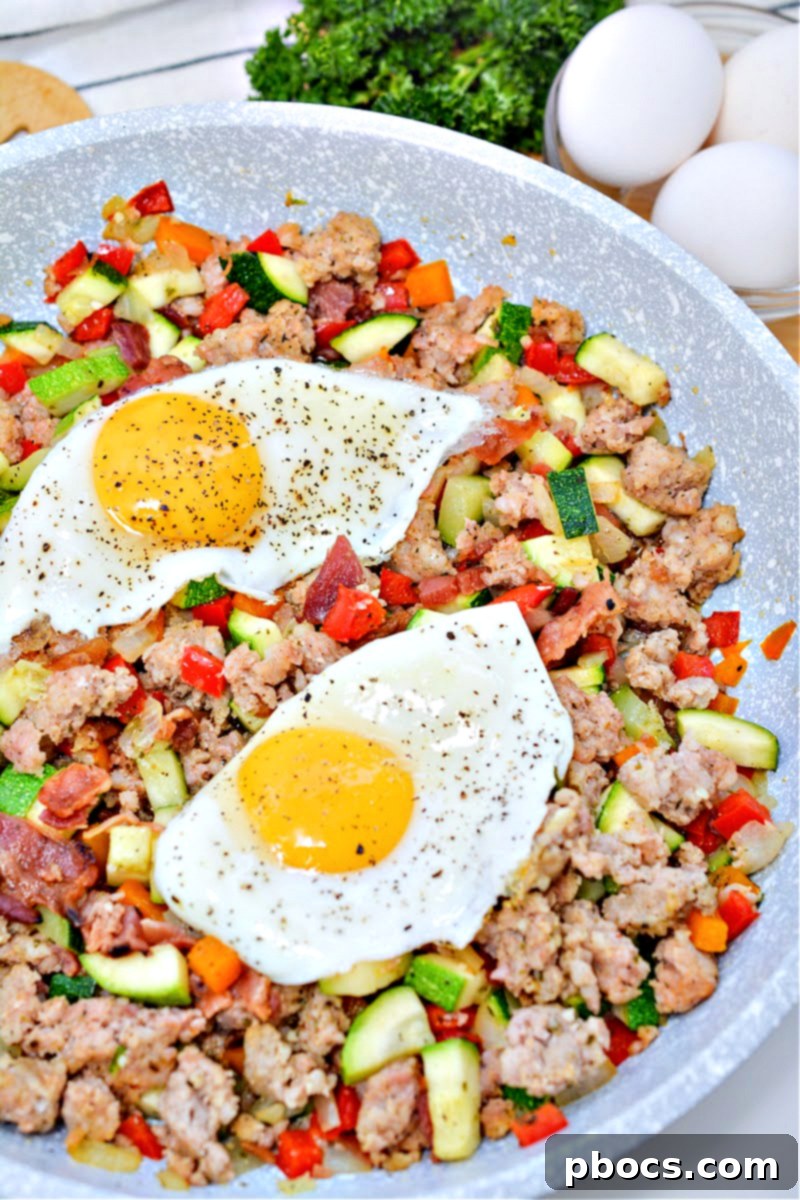 Keto Sausage Zucchini Breakfast Skillet 7 A delicious serving of Keto Sausage and Zucchini Breakfast Hash topped with a perfectly fried egg, ready to eat.